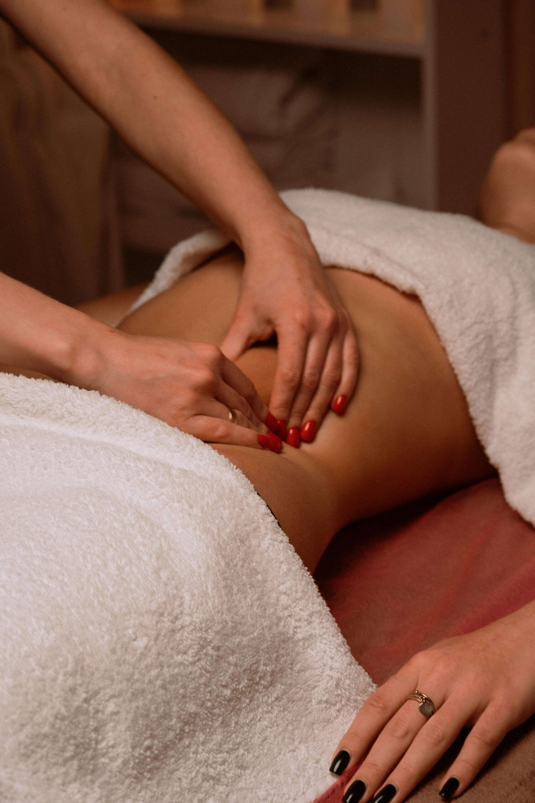 Woman receiving abdominal massage in lincoln, nebraska for painful periods, digestive issues.